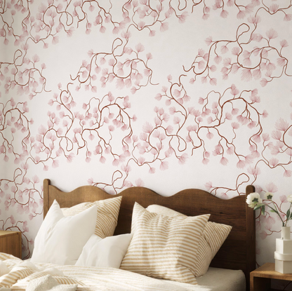 a bedroom with a wooden headboard and a bed covered in white and beige striped pillows. The wall behind the bed has a floral pattern in shades of pink and white.