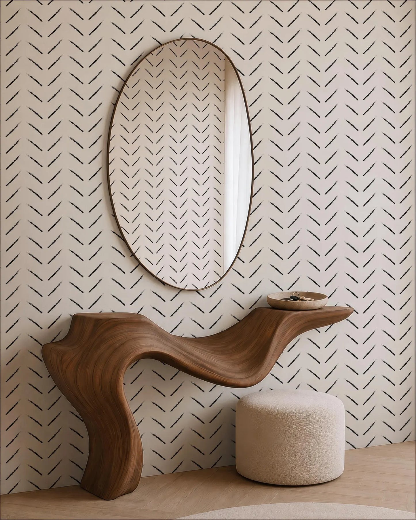 a modern, wooden console table with a curved, organic design, positioned against a wall with a large oval mirror above it. The wall has a black and white chevron pattern, creating a visually striking contrast with the wooden table.