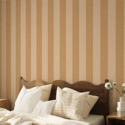 a cozy bedroom with a wooden headboard and a bed covered in white and beige striped pillows. The walls are adorned with a striped wallpaper, creating a warm and inviting atmosphere.