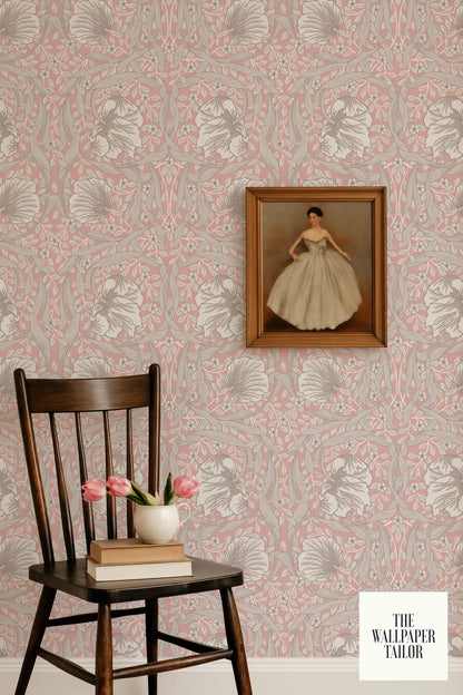 a wooden chair with a vase of pink flowers and a framed painting of a woman on the wall.