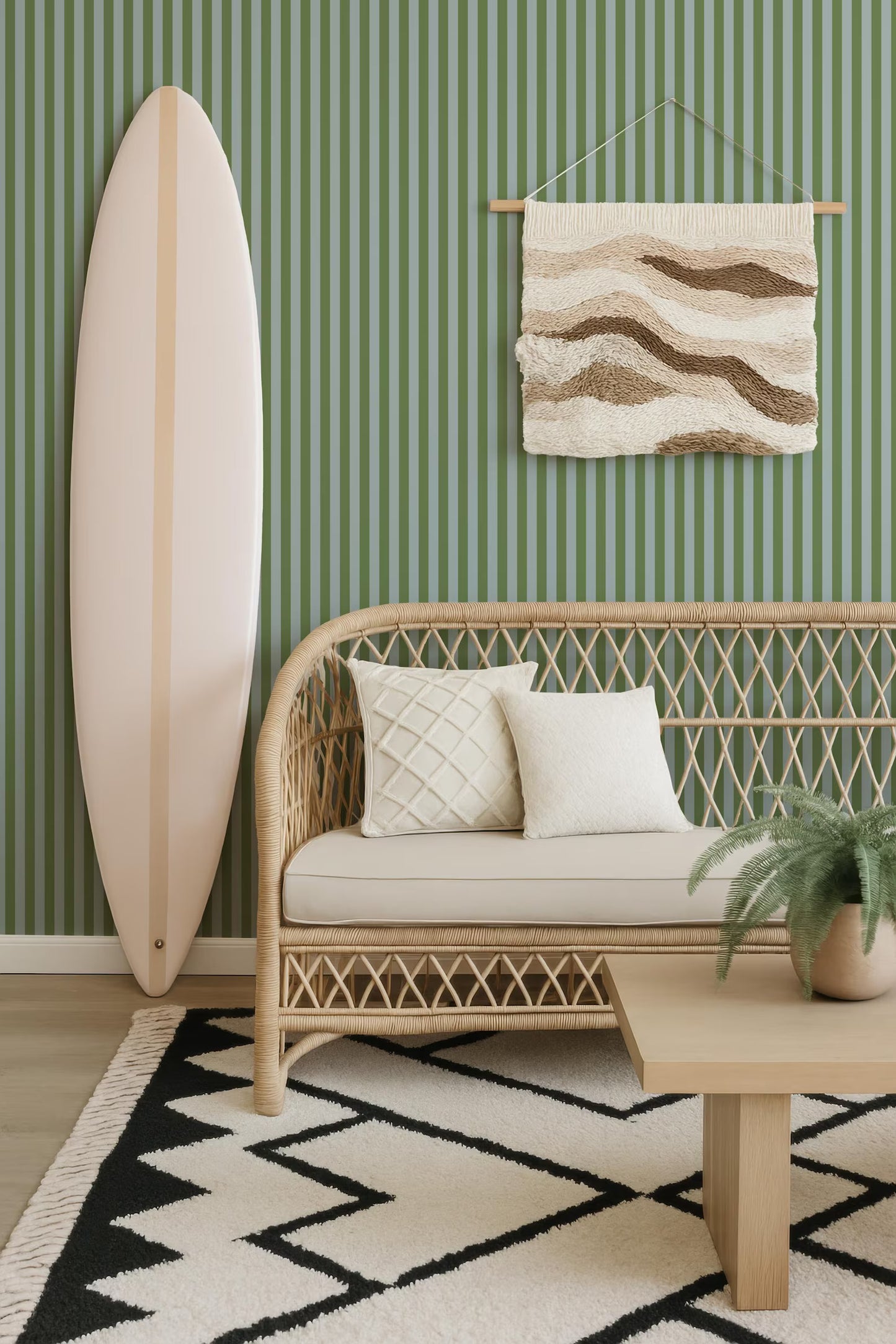 a living room with a white surfboard leaning against the wall, a wicker sofa with white pillows, a woven coffee table, and a geometric rug on the floor.