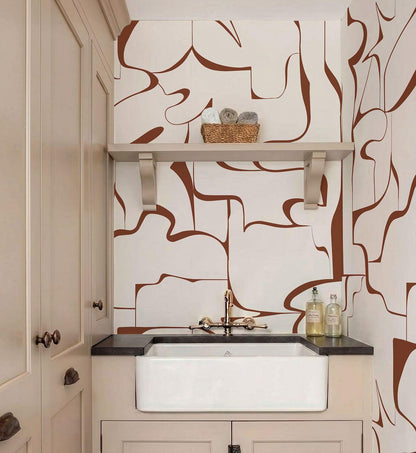 a bathroom with a white sink and a shelf above it. The wall behind the sink has a unique abstract pattern in shades of brown and white. There are also some bottles placed on the countertop.
