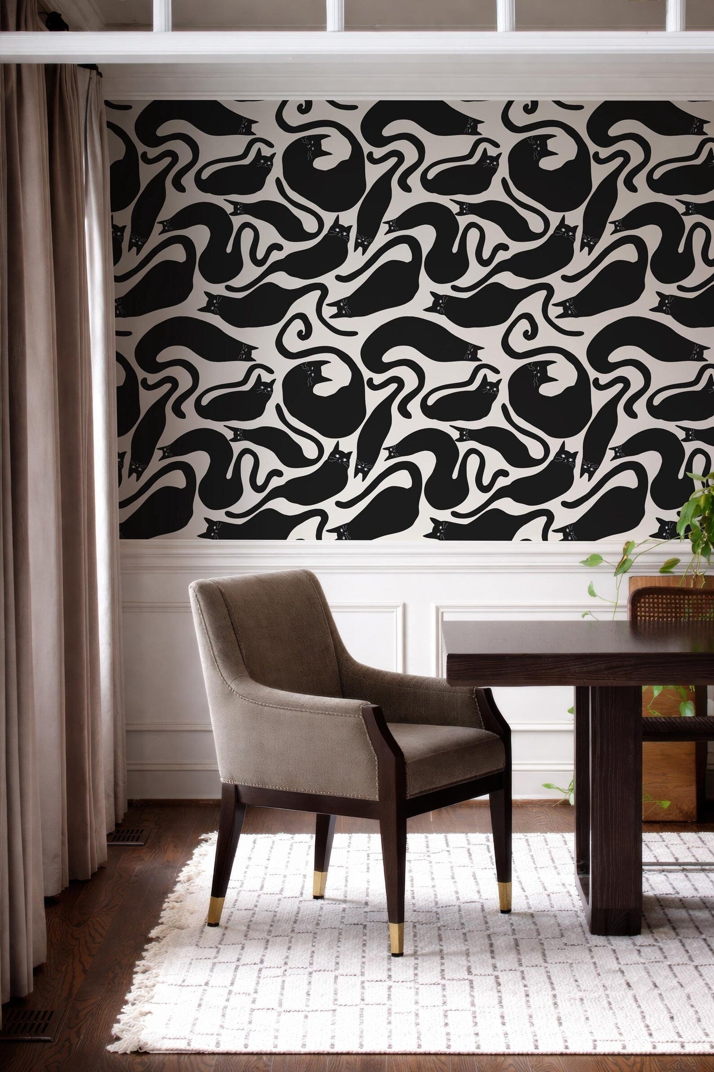 a modern interior design with a black and white patterned wallpaper on the wall behind a wooden dining table with a gray upholstered chair.