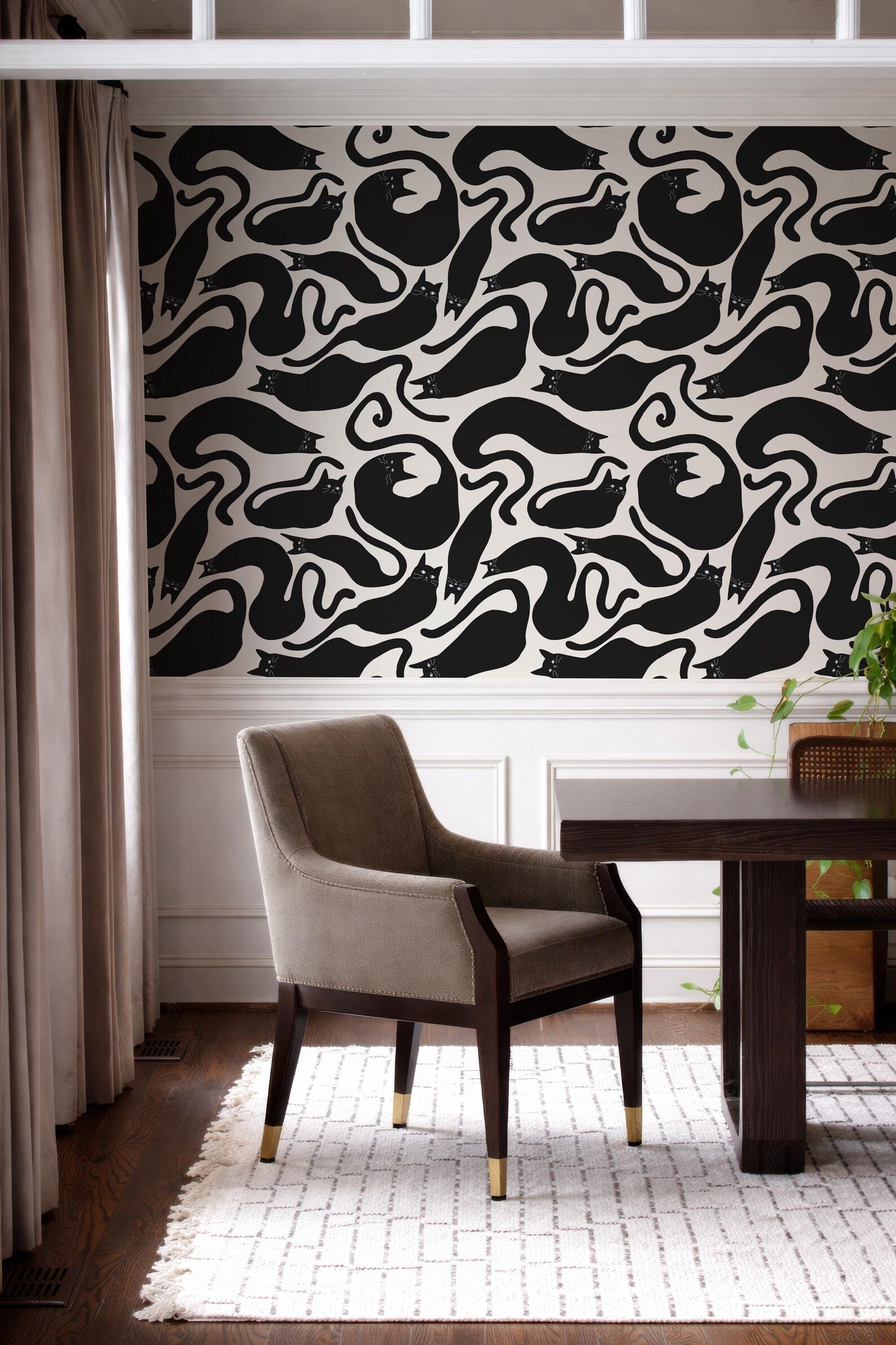 a modern interior design with a black and white patterned wallpaper on the wall behind a wooden dining table with a gray upholstered chair.
