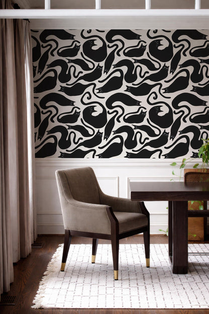 a modern interior design with a black and white patterned wallpaper on the wall behind a wooden dining table with a gray upholstered chair.