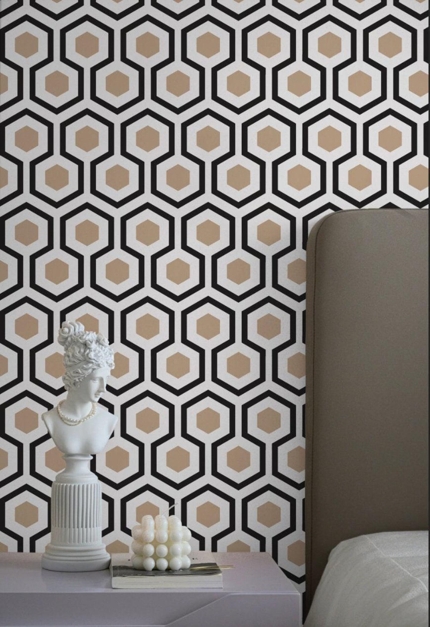 a white bust on a white table, with a geometric patterned wallpaper in the background.