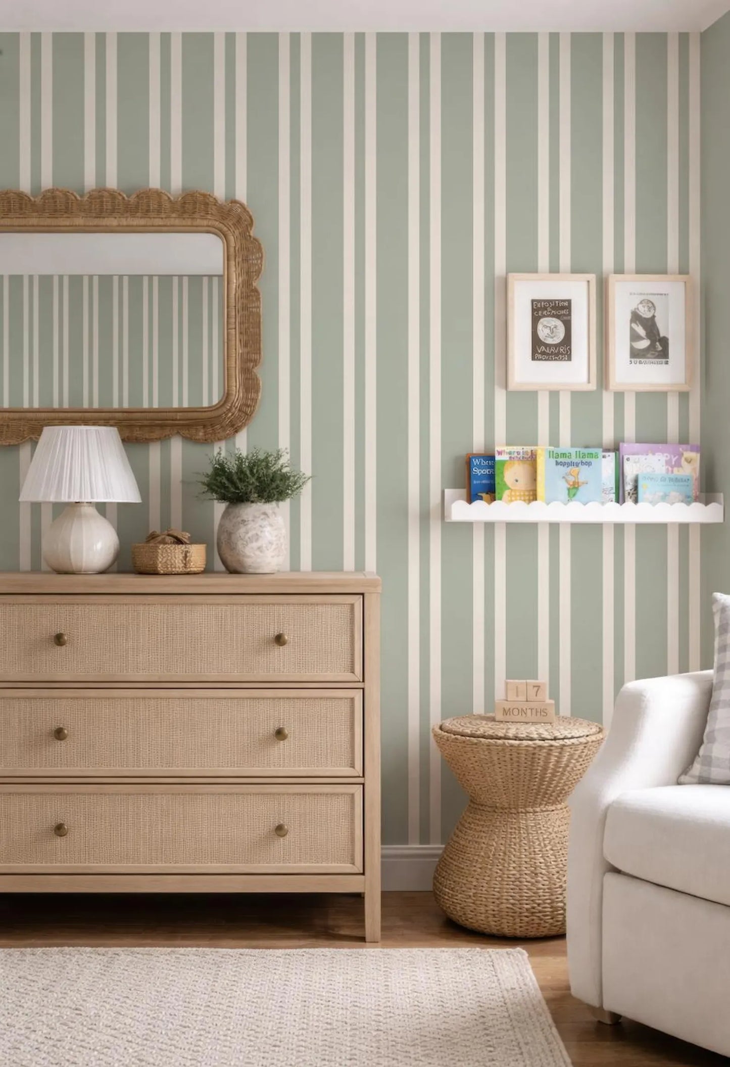 a cozy and well-decorated living room with a striped green and white wallpaper, a wooden dresser, a mirror, a bookshelf, and a wicker side table.