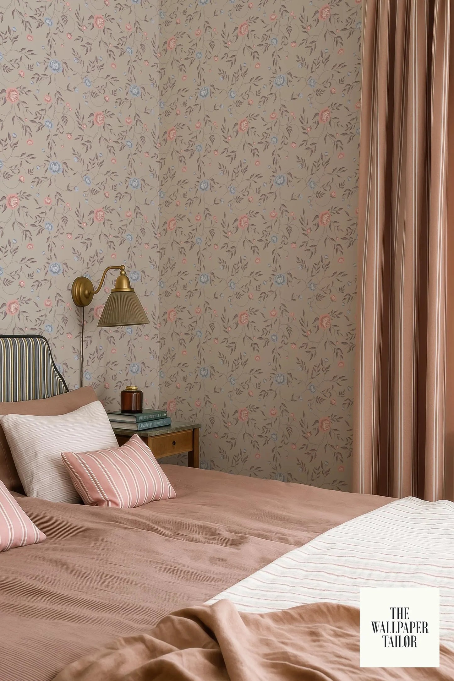 a cozy bedroom with a floral wallpaper, a bed with a pink and white striped comforter, and a nightstand with a lamp.