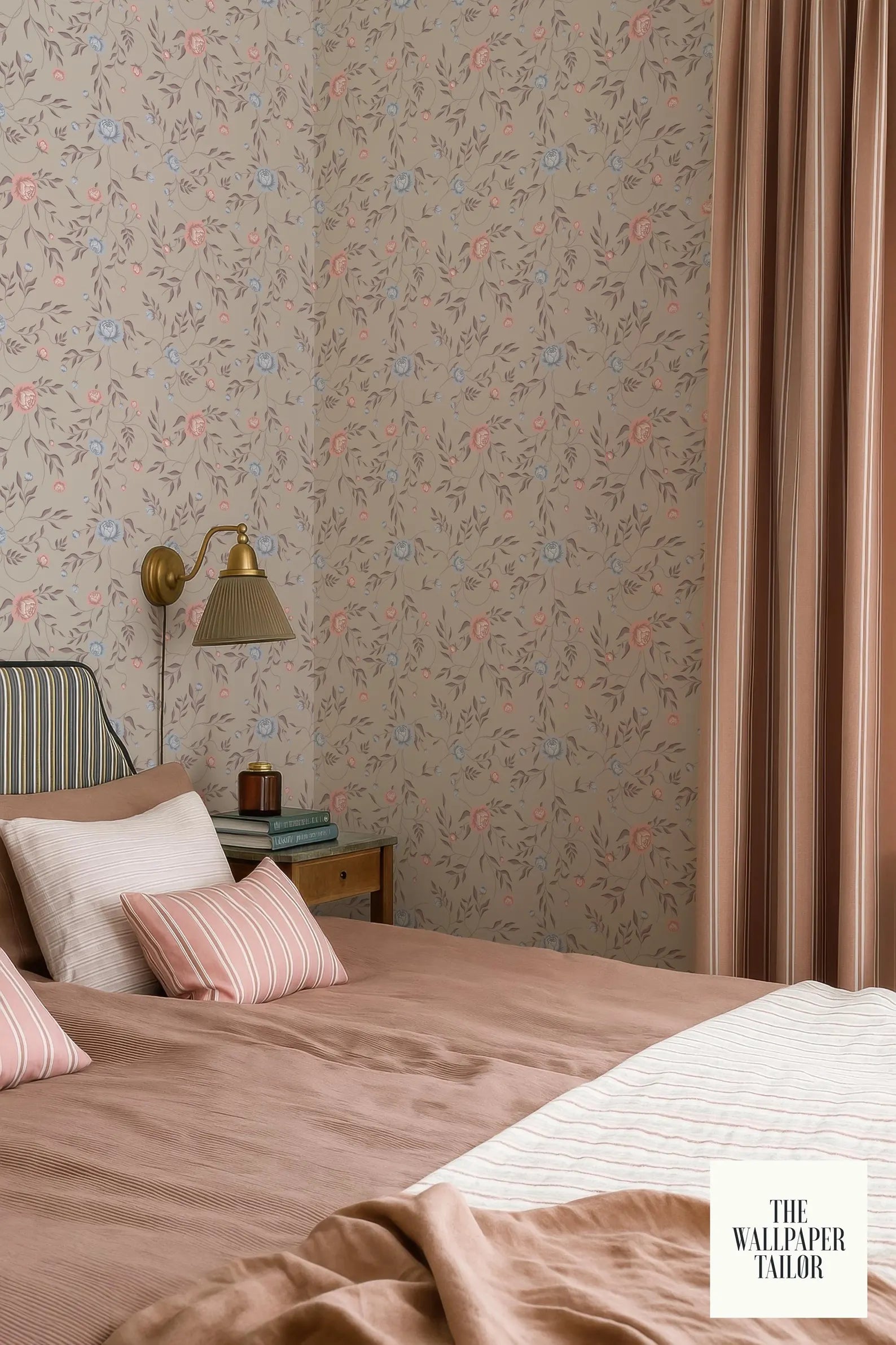a cozy bedroom with a floral wallpaper, a bed with a pink and white striped comforter, and a nightstand with a lamp.
