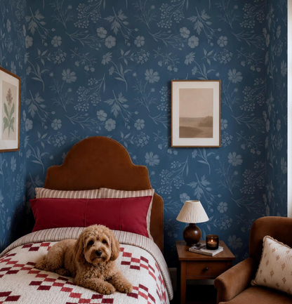 a cozy bedroom scene with a brown dog resting on a bed, a wooden nightstand with a lamp, and a framed picture on the wall.