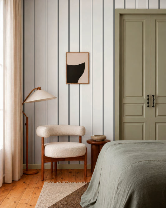 a modern bedroom with a striped wallpaper, a wooden chair, a bed, and a nightstand.