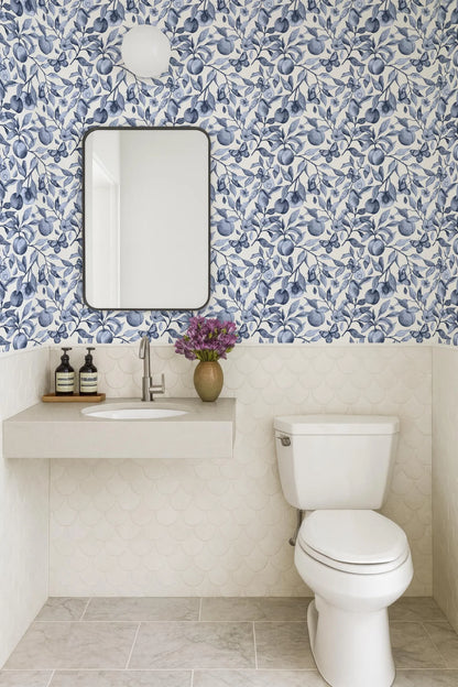 a bathroom with a white toilet, a sink with a mirror above it, and a blue and white floral wallpaper on the walls.