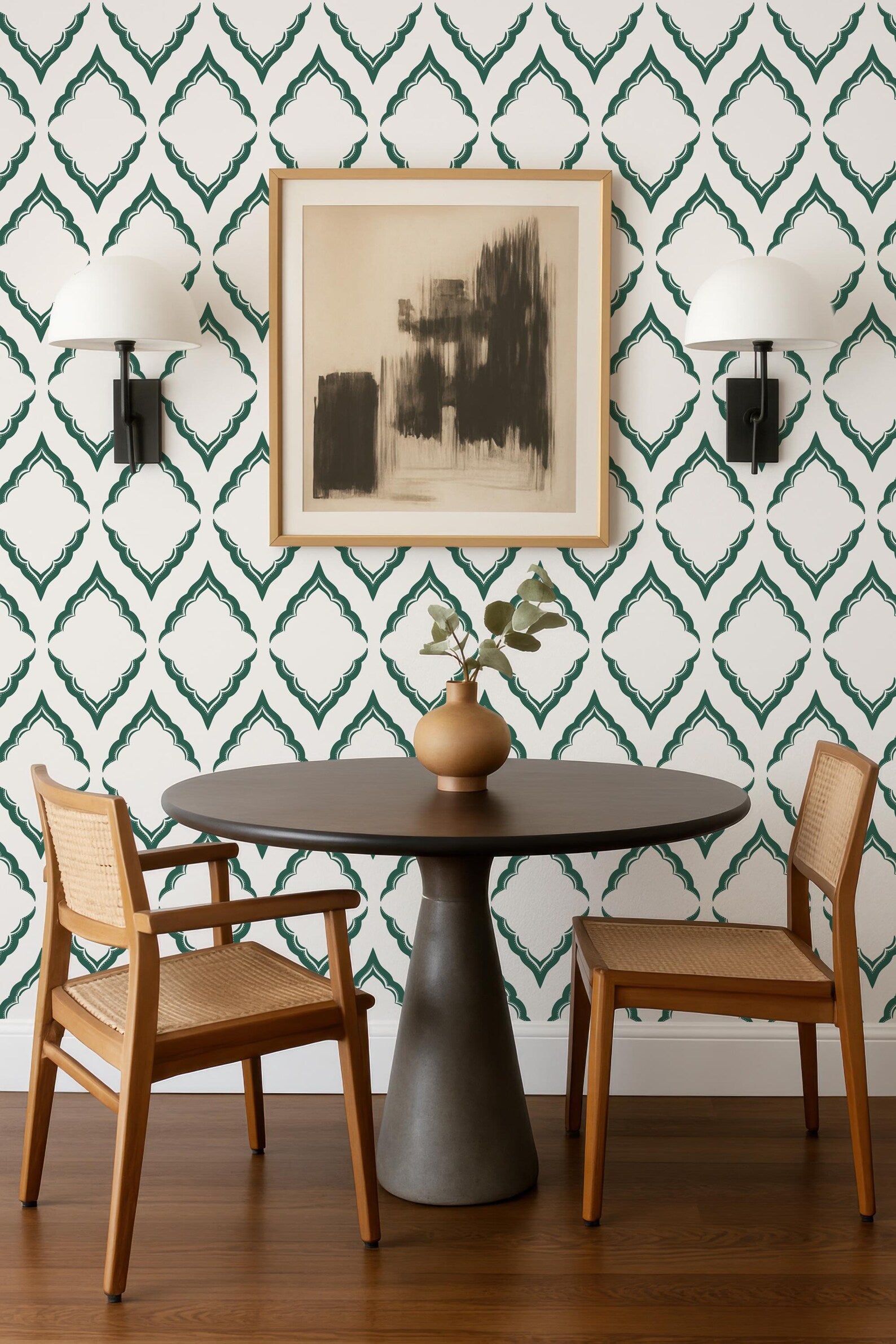 a modern dining area with a round wooden table, two wooden chairs, and a framed abstract artwork on the wall above the table.