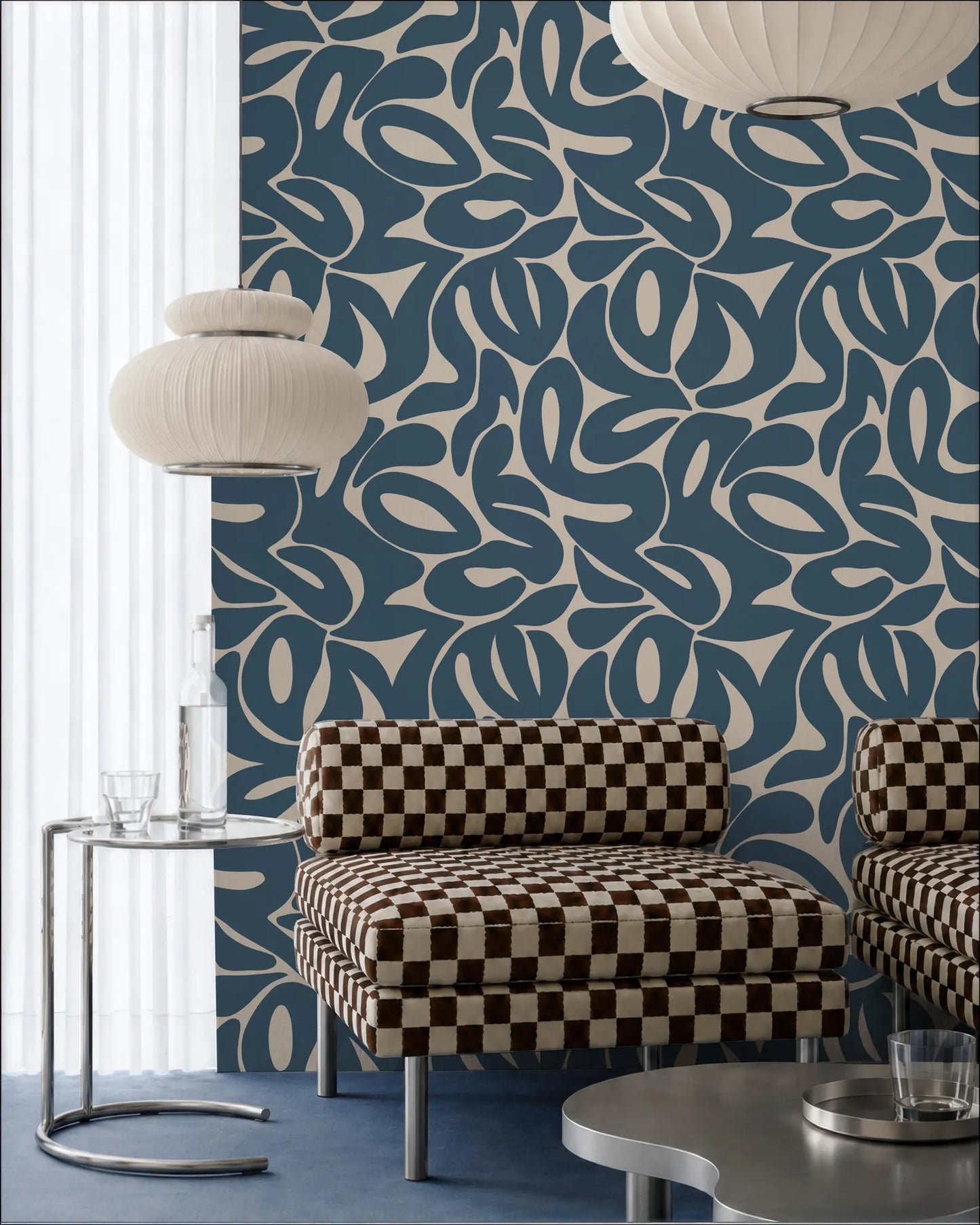 a modern living room with a checkered patterned sofa, a glass side table, and a large wall with a blue and white abstract pattern.
