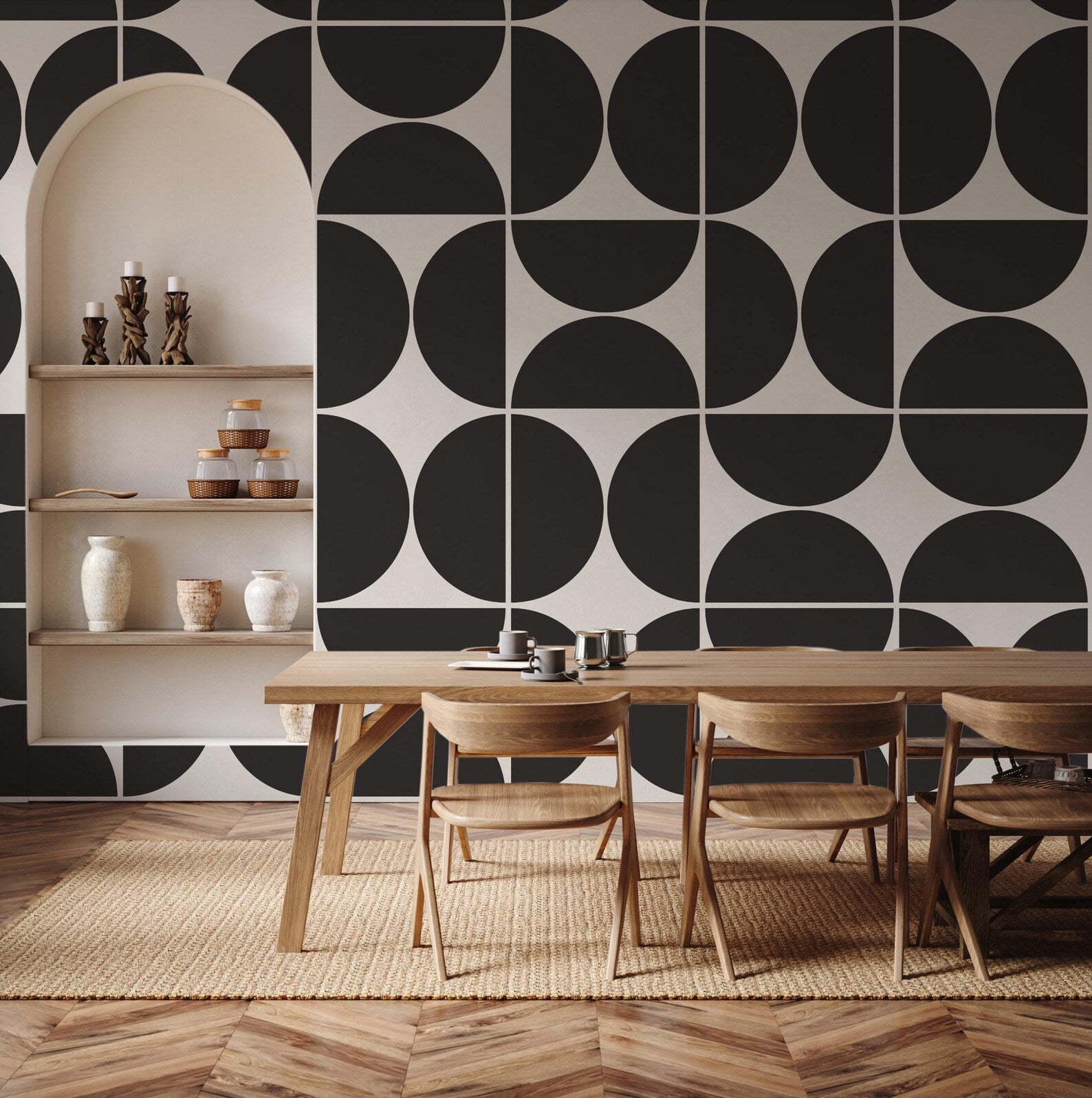 a modern dining room with a wooden table and chairs, a white shelf with decorative items, and a black and white geometric pattern on the wall behind the table.