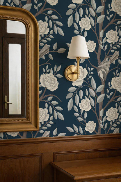 a dark blue wall with a gold-framed mirror and a gold-framed wall lamp, creating a sophisticated and elegant atmosphere.