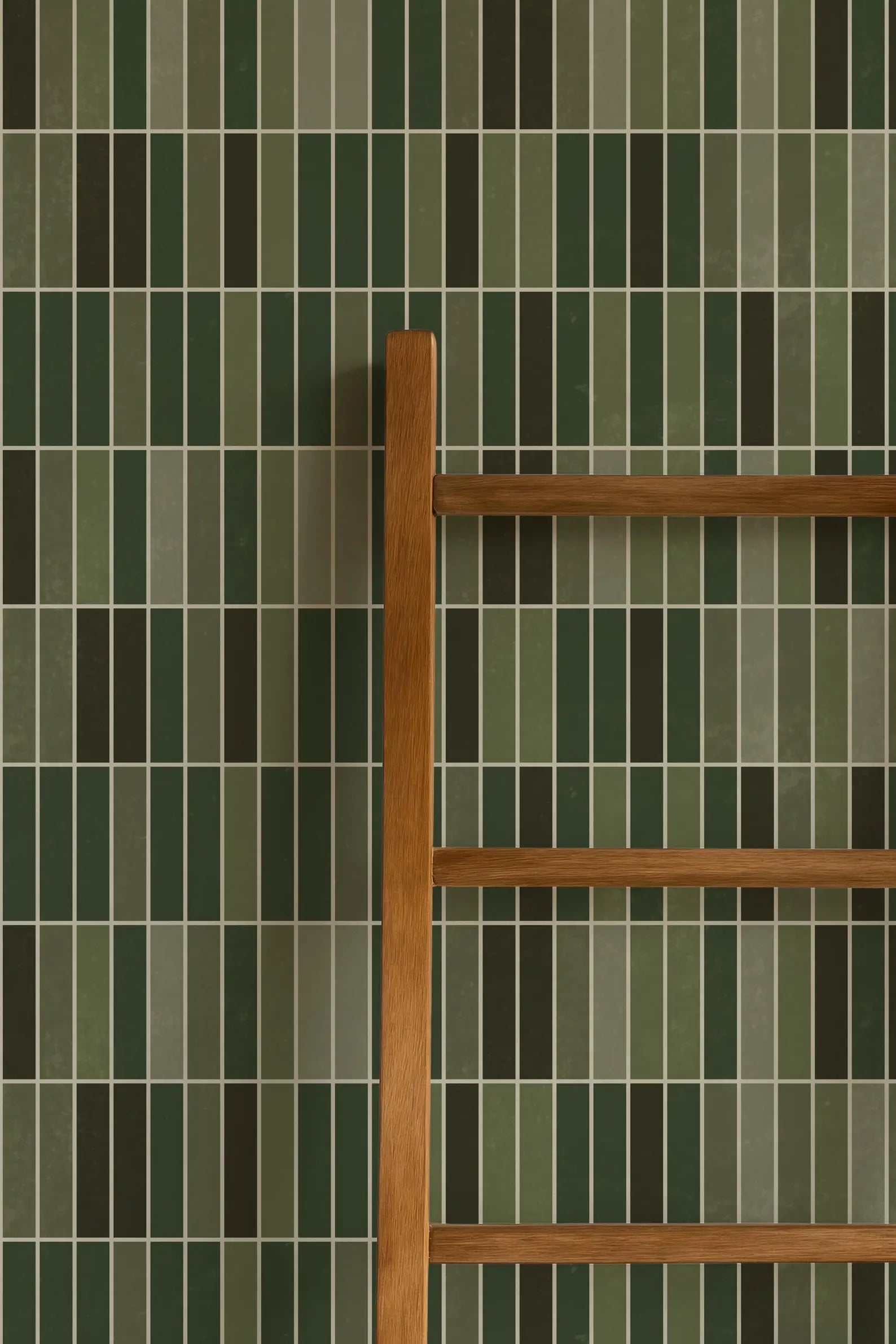 a wooden ladder leaning against a wall with green and brown tiles.