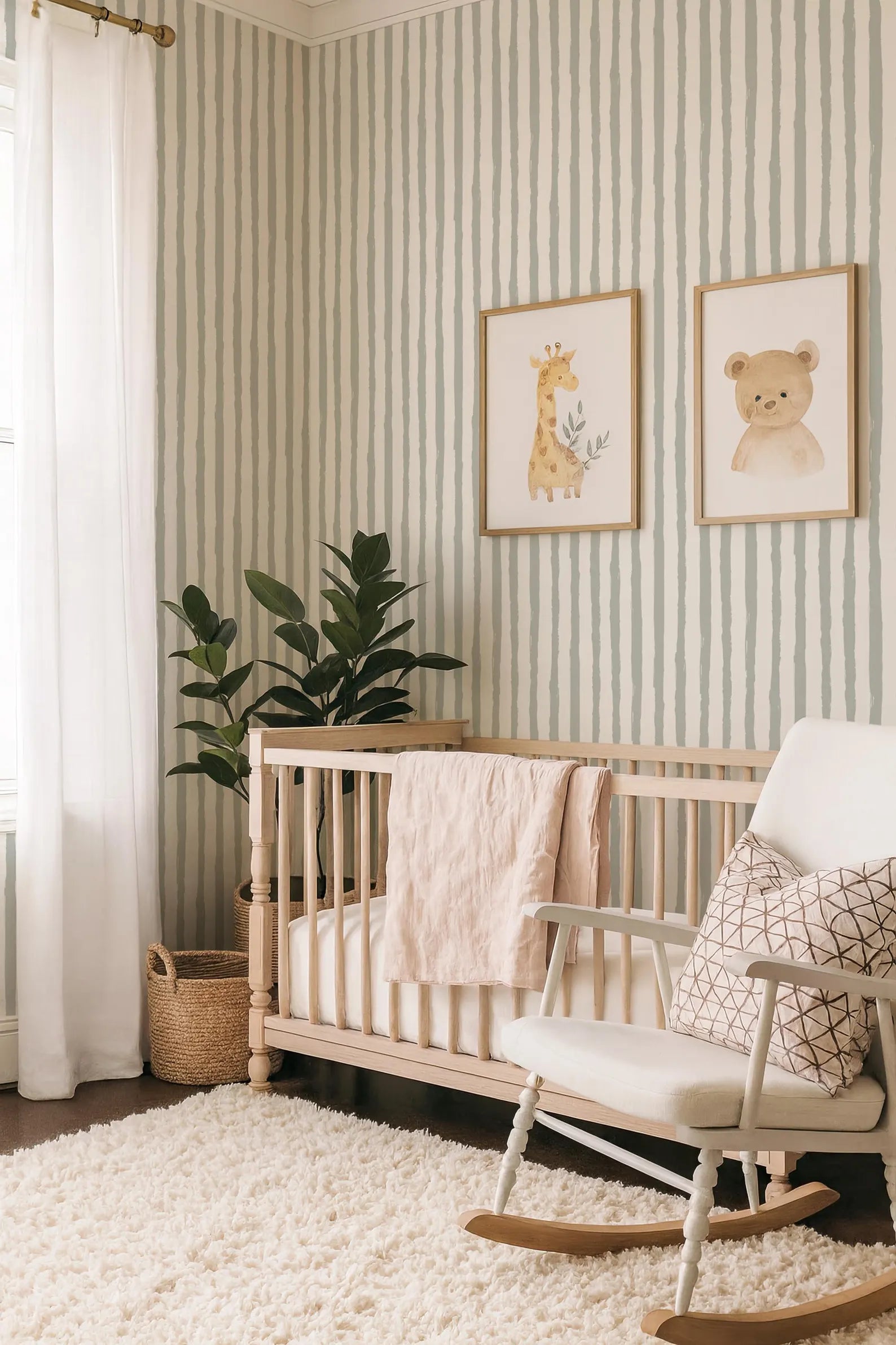 a cozy nursery with a wooden crib, a white rocking chair, and two framed animal prints on the wall. The room is decorated with a striped wallpaper, a plush rug, and a potted plant, creating a warm and inviting atmosphere.