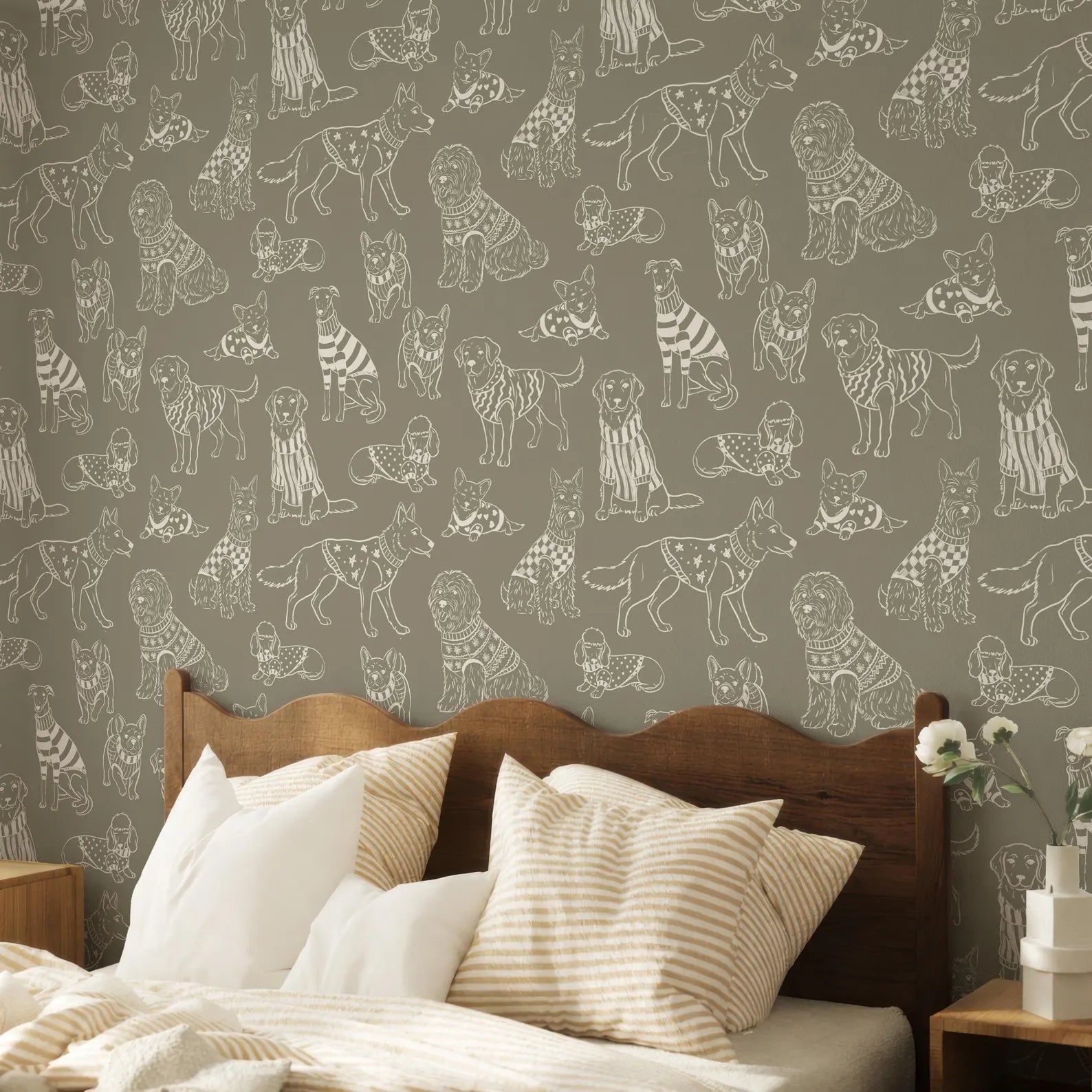 a bedroom with a wooden headboard and a bed with striped pillows. The wall behind the bed has a repeating pattern of stylized illustrations of dogs in various poses and outfits.