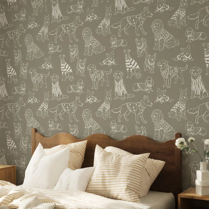 a bedroom with a wooden headboard and a bed with striped pillows. The wall behind the bed has a repeating pattern of stylized illustrations of dogs in various poses and outfits.