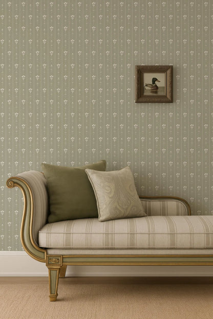 a beige sofa with a gold frame, placed against a wall with a floral wallpaper. A framed picture of a duck is hanging on the wall above the sofa.