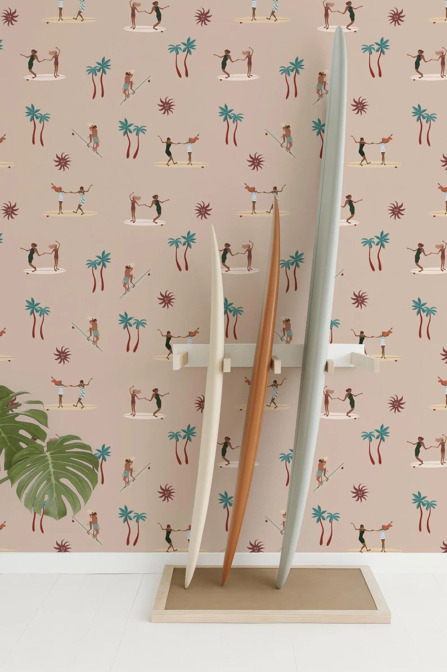 three surfboards standing upright against a wall with a repeating pattern of palm trees and people surfing.