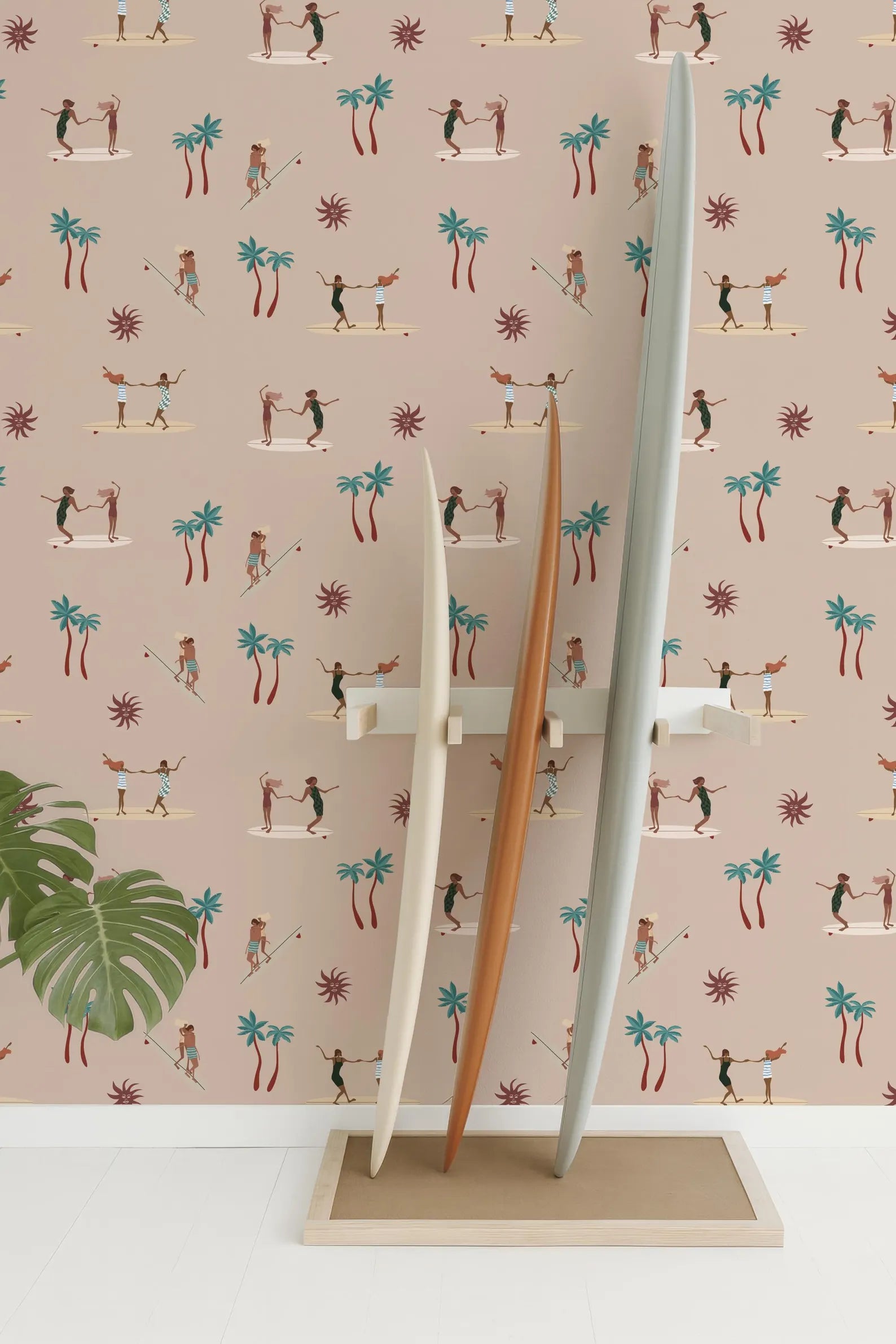 three surfboards standing upright against a wall with a repeating pattern of palm trees and people surfing.