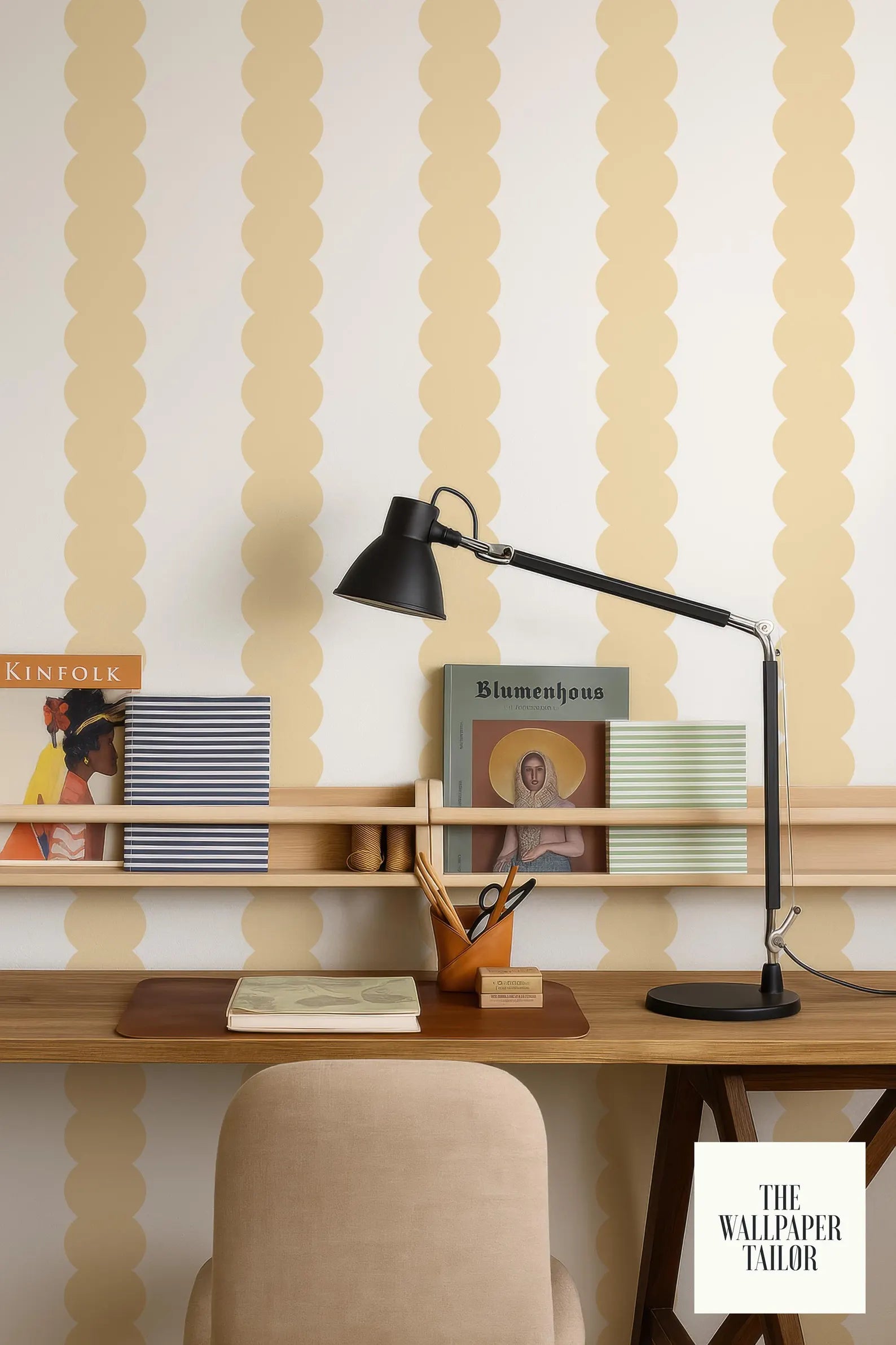 a workspace with a wooden desk, a lamp, and various items such as books and a magazine. The wall behind the desk has a pattern of yellow and white circles, creating a visually appealing backdrop. The workspace appears to be well-organized and functional, with the lamp providing adequate lighting for the tasks at hand.