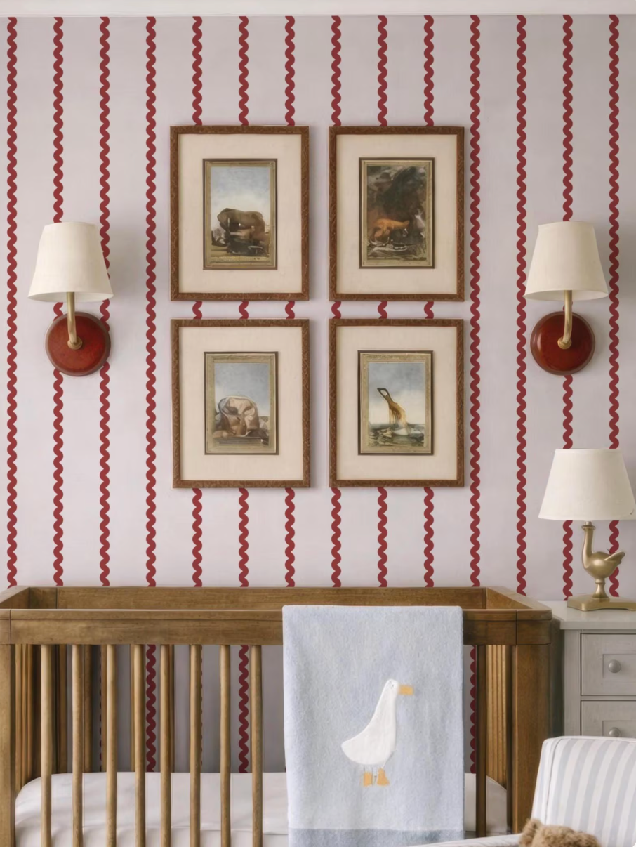 a nursery room with a wooden crib, framed artwork on the wall, and two lamps on either side of the crib.