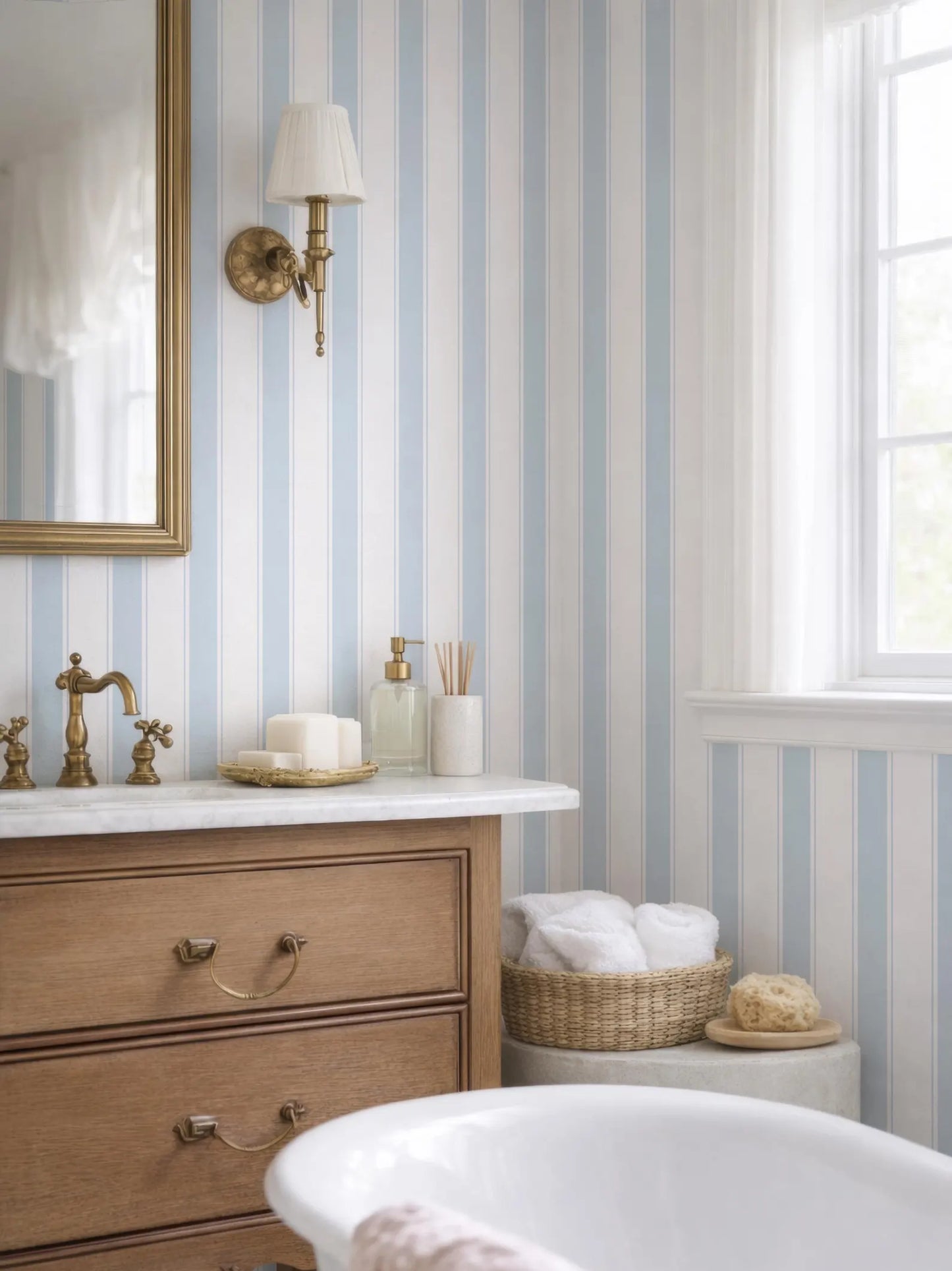 a bathroom with a white bathtub, a wooden dresser, and a striped wallpaper. The bathroom has a white and blue color scheme, and there is a window providing natural light.