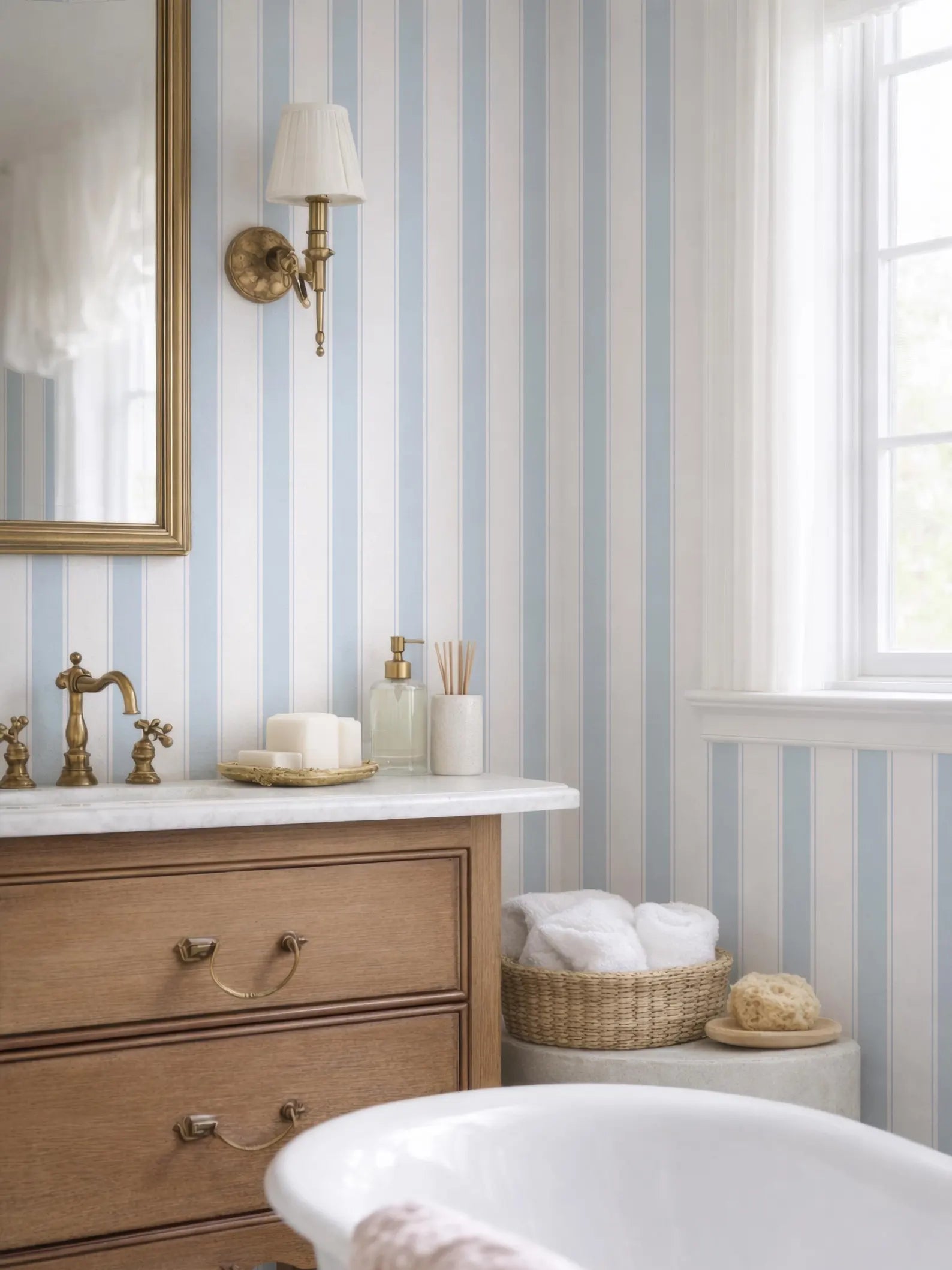 a bathroom with a white bathtub, a wooden dresser, and a striped wallpaper. The bathroom has a white and blue color scheme, and there is a window providing natural light.