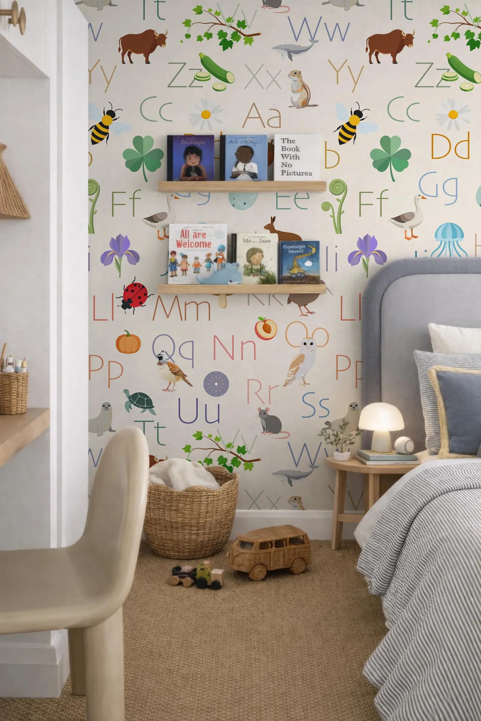 a child's bedroom with a colorful alphabet wall, a bookshelf, and a bed. The wall is decorated with various animal illustrations and letters, creating a vibrant and playful atmosphere.