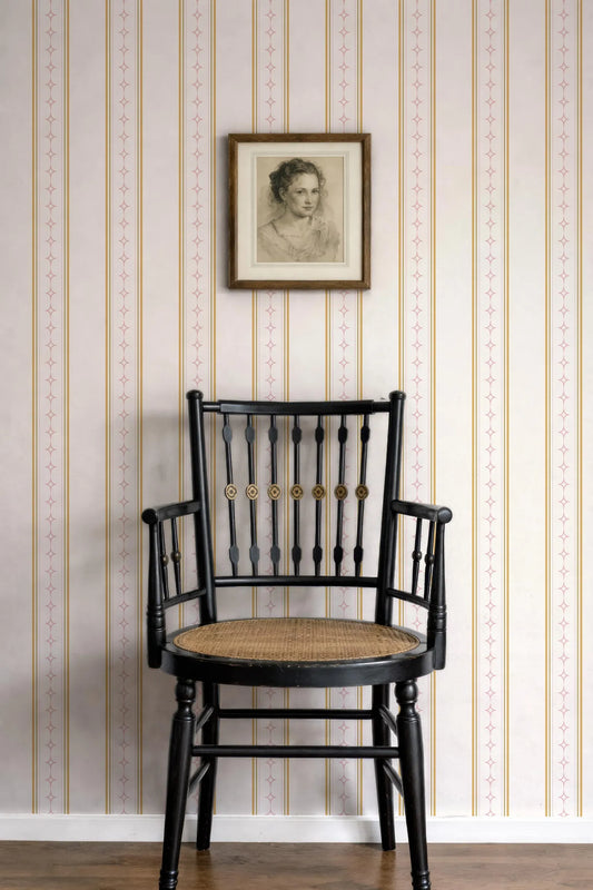a black wooden chair with a woven seat, positioned against a wall with a framed portrait hanging above it.