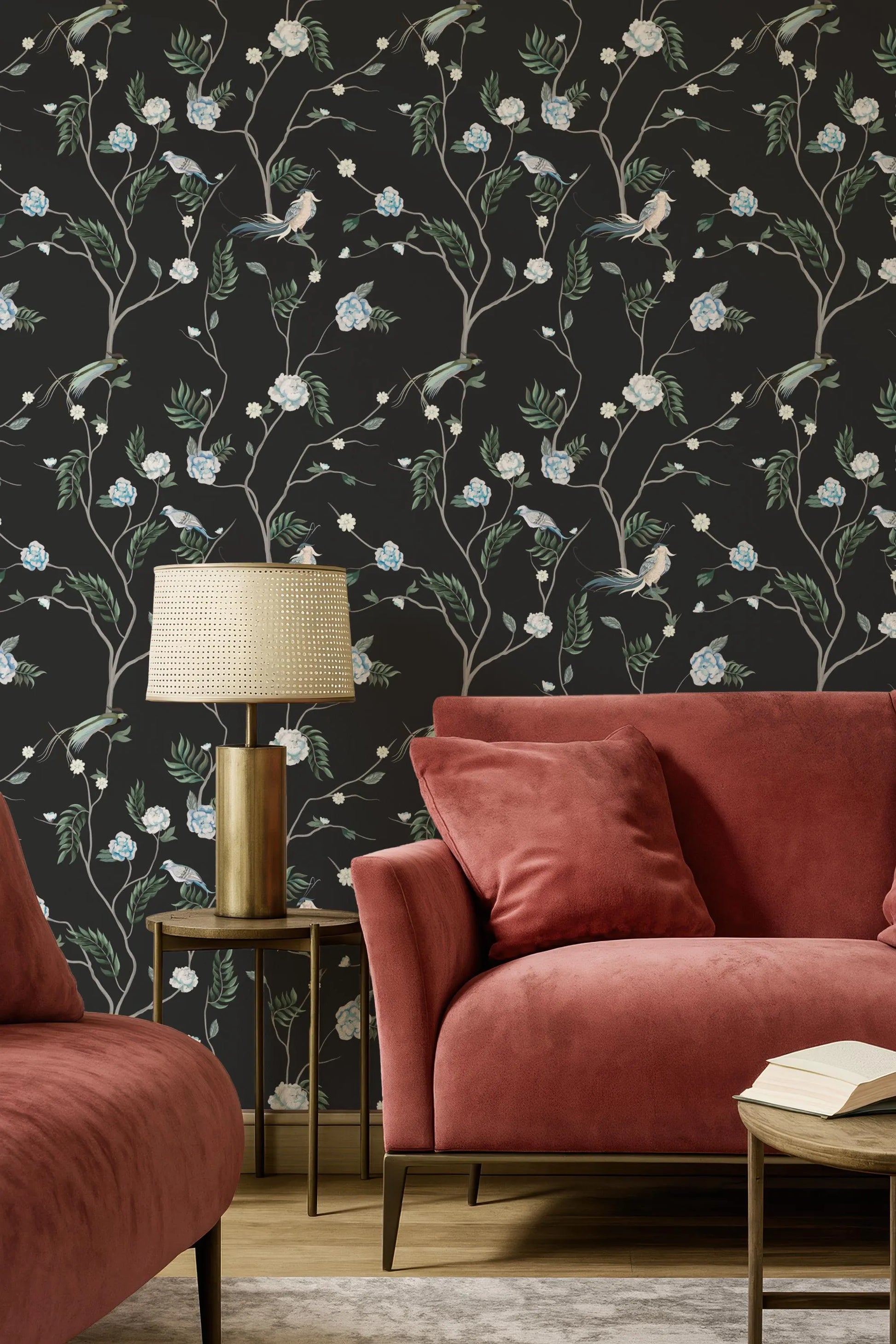 a living room with a red sofa, a gold side table with a lamp, and a black wall with a floral wallpaper.
