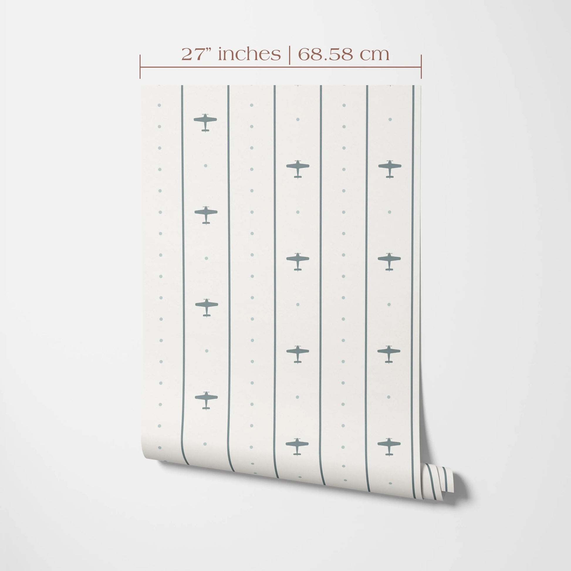 a wallpapered wall with a repeating pattern of small airplane silhouettes. The wallpapered wall is 27 inches tall and 68.58 cm in width.