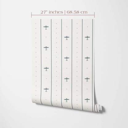 a wallpapered wall with a repeating pattern of small airplane silhouettes. The wallpapered wall is 27 inches tall and 68.58 cm in width.