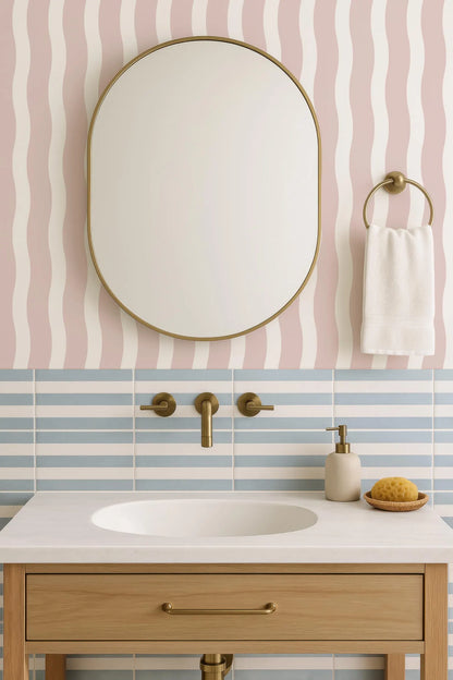 a bathroom sink with a white countertop, a round mirror above it, and a towel rack on the wall. The bathroom has a pink and white striped pattern on the walls, and the sink is made of wood.