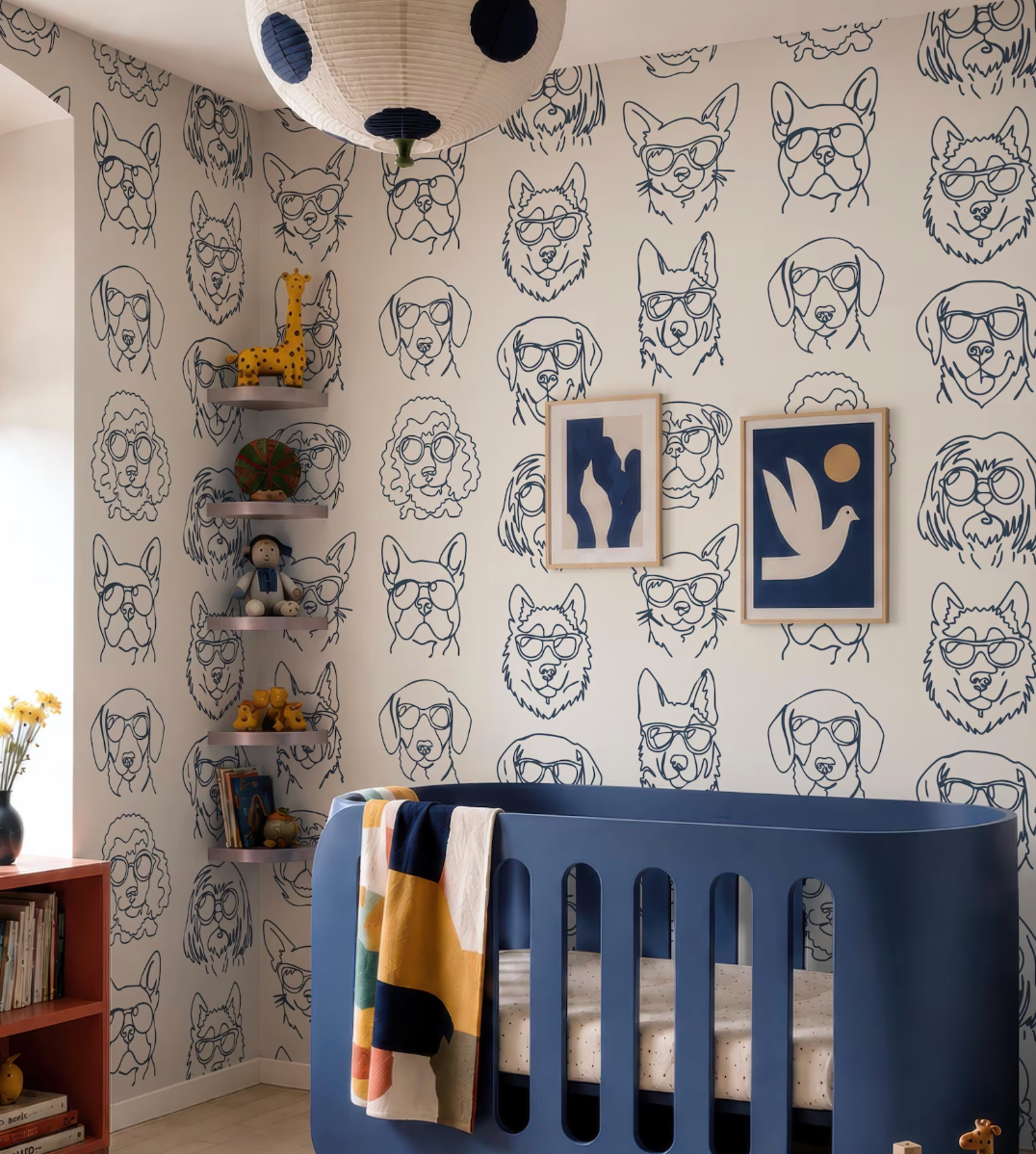 a nursery room with a blue crib, a wall covered in a repeating pattern of dog faces, and a hanging lamp.