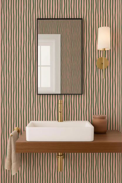 a bathroom with a white rectangular sink, a mirror above it, and a wooden shelf below the sink. The walls are covered in a striped pattern in shades of green and pink.