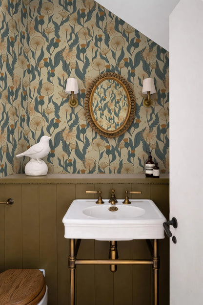 a bathroom with a white sink, a round mirror, and a bird figurine on a shelf. The walls are covered in a floral wallpaper, and there are two wall sconces above the sink.
