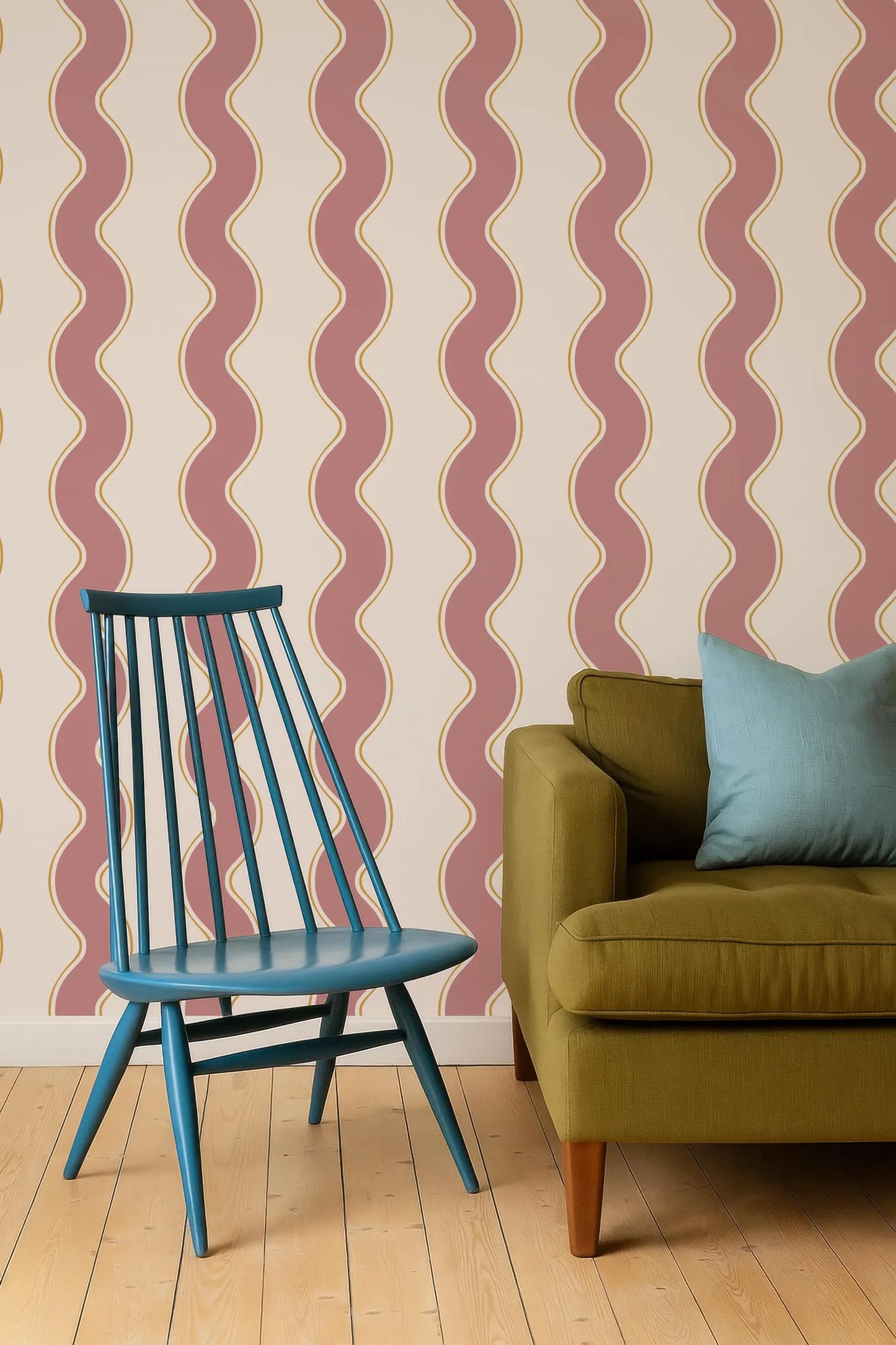 a blue chair and a green sofa against a wall with a repeating pattern of red and white wavy lines.