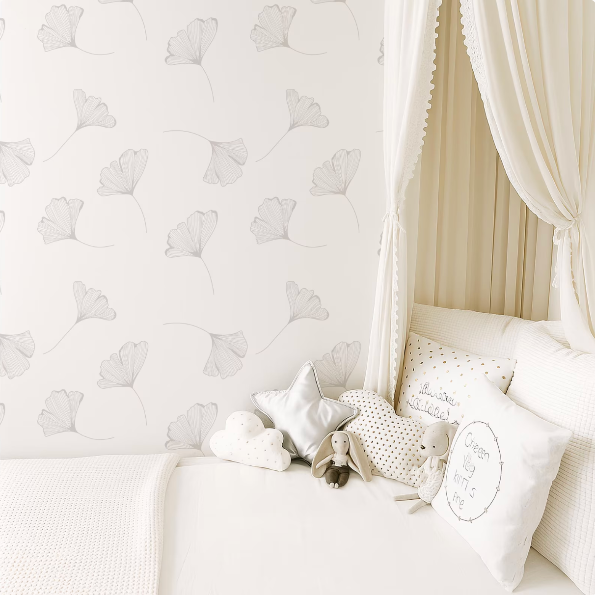 a cozy and inviting bedroom scene, featuring a canopy bed with a white canopy and a gray and white floral wallpaper. The bed is adorned with white pillows and a stuffed animal, creating a warm and comfortable atmosphere.