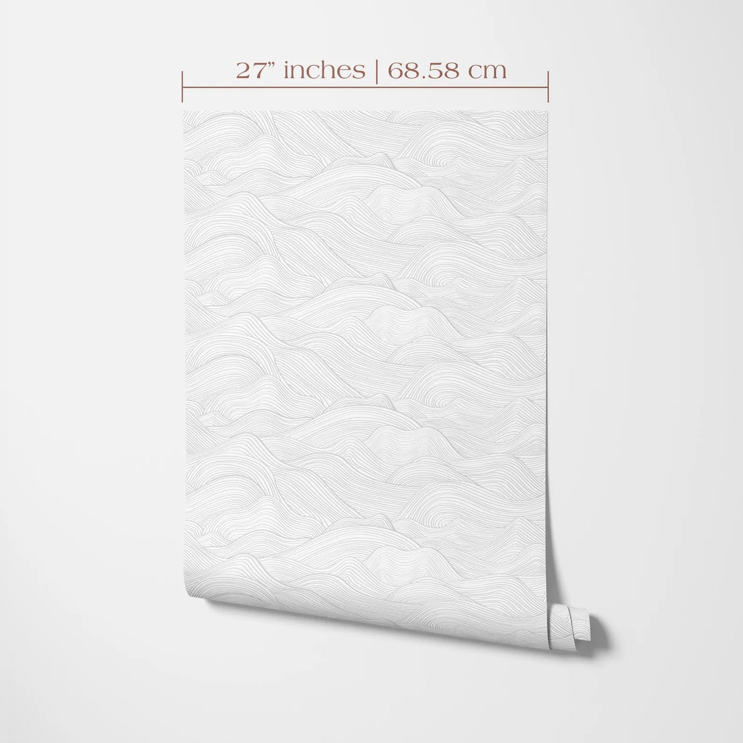 a white wall with a rolled-up wallpaper or paper with a repeating pattern of wavy lines, likely resembling a mountain landscape.