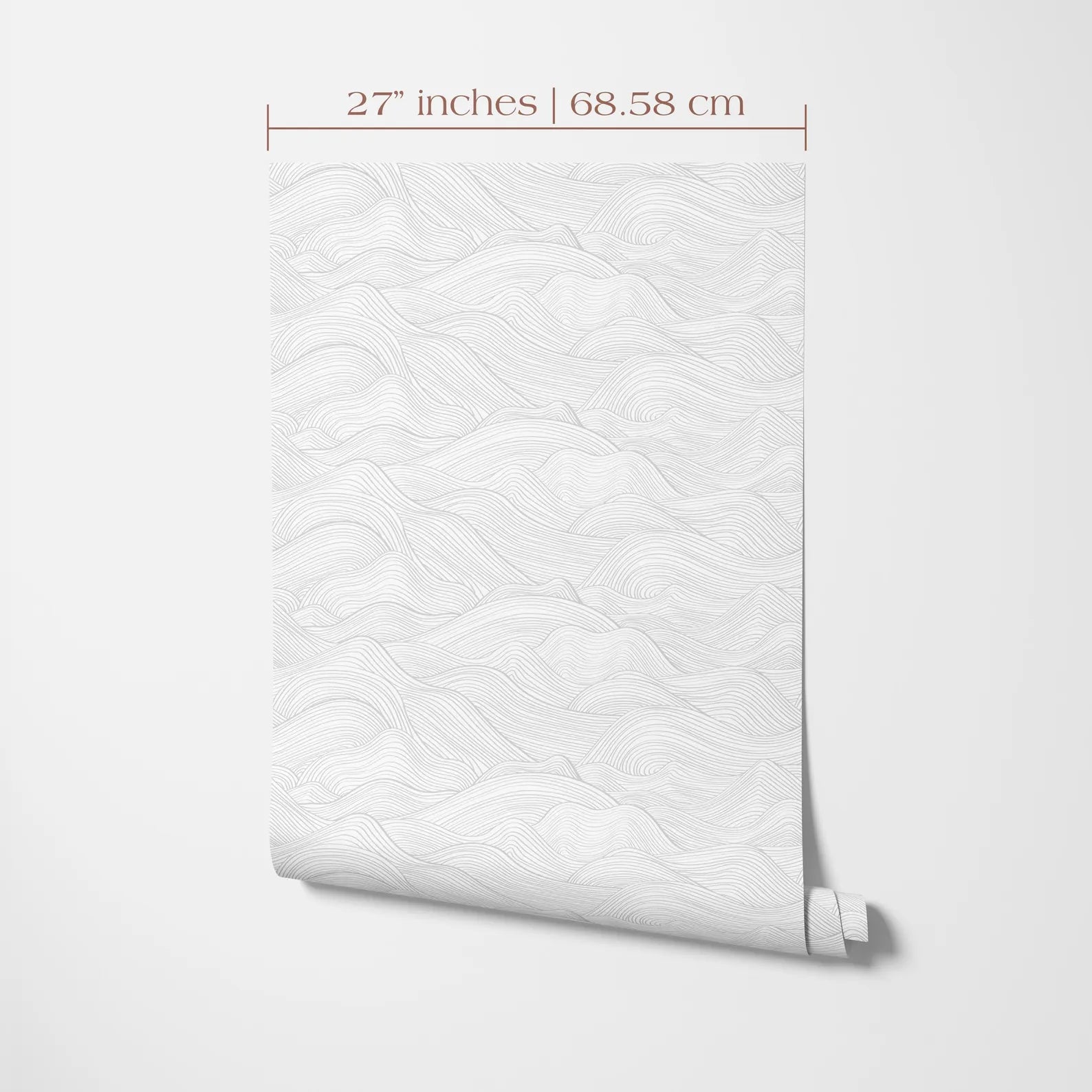 a white wall with a rolled-up wallpaper or paper with a repeating pattern of wavy lines, likely resembling a mountain landscape.