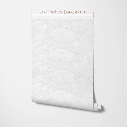 a white wall with a rolled-up wallpaper or paper with a repeating pattern of wavy lines, likely resembling a mountain landscape.