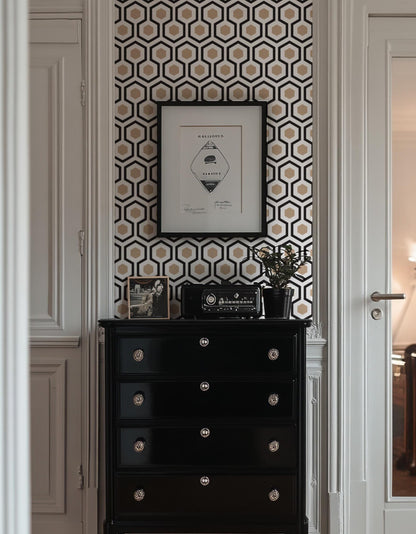 a black dresser with a framed picture and a radio on top, set against a wall with a geometric pattern wallpaper.
