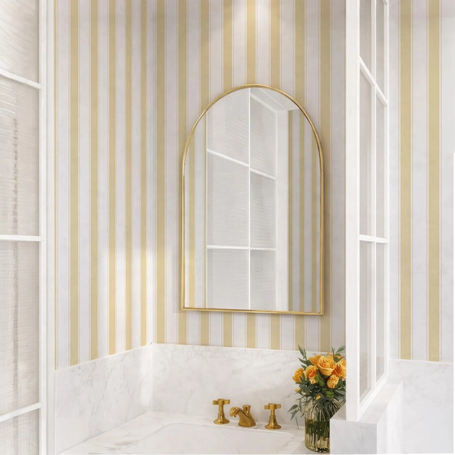 a bathroom with a white marble sink, a gold-framed mirror, and a vase of yellow flowers on the counter.