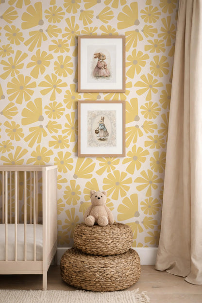 a nursery room with a yellow and white floral wallpaper, a wooden crib, and two framed pictures of rabbits on the wall. A small stuffed teddy bear is sitting on a woven basket in the foreground.