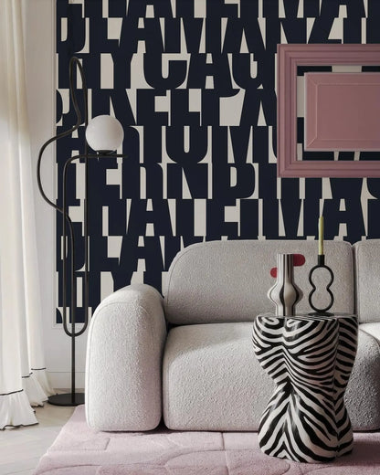 a modern living room with a white sofa, a zebra-patterned side table, and a black floor lamp. The wall behind the sofa has a large black and white text design, creating a bold and striking visual element in the space.