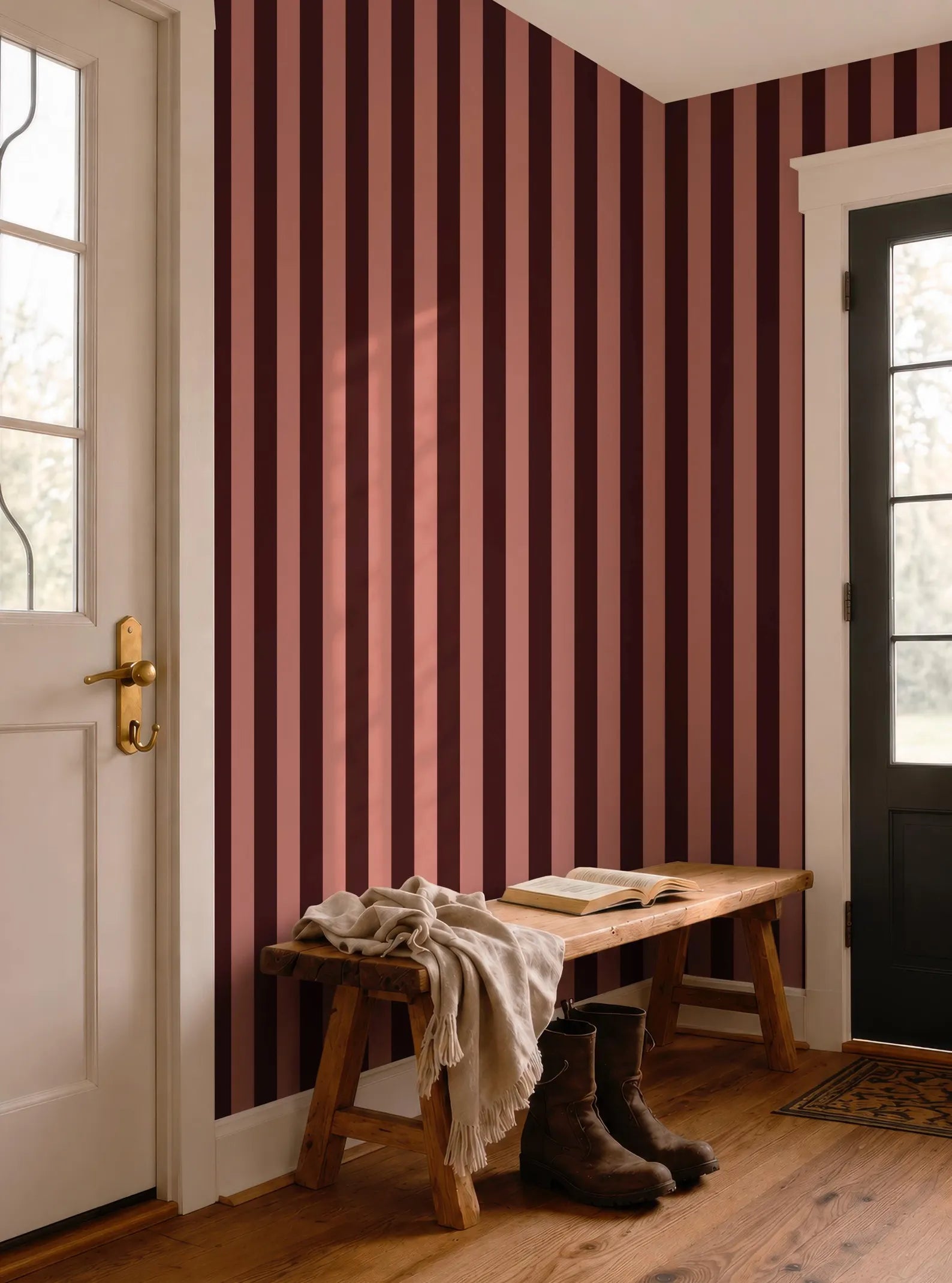a wooden bench with a blanket and a pair of boots placed on it, situated in a room with a red and black striped wall.